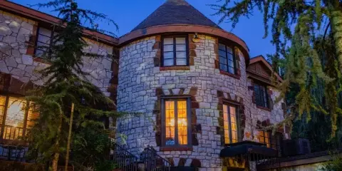 Exterior view of the stone castle building at Castle Falls venue at dusk.