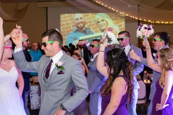 Wedding reception dance floor with the couple and guests dancing under event lighting.