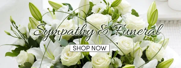 A close-up photograph of a floral arrangement consisting of white roses and white lilies with green foliage.