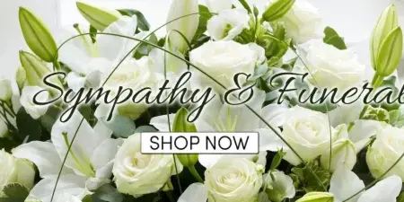 A close-up photograph of a floral arrangement consisting of white roses and white lilies with green foliage.