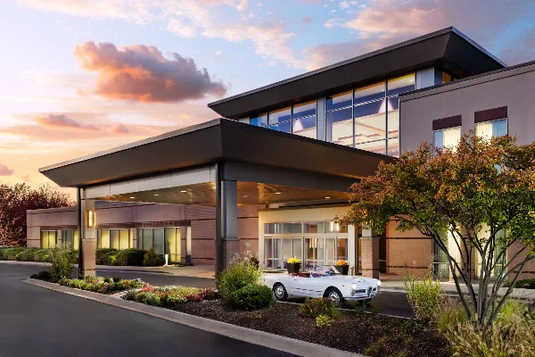 Exterior view of the Eaglewood Resort & Spa building at dusk with a white classic car parked at the entrance.