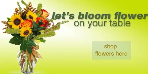 A vase containing a colorful bouquet of sunflowers, orange roses, and greenery.