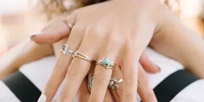 Close-up of a couple's hands showing wedding rings and manicured nails.