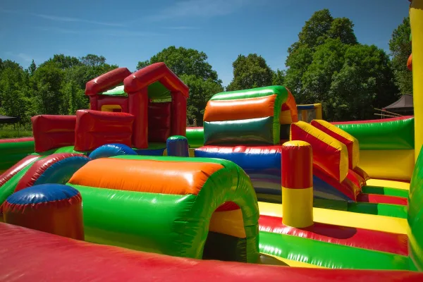 A colorful inflatable obstacle course set up outdoors on a sunny day.
