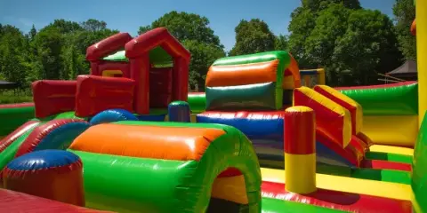 A colorful inflatable obstacle course set up outdoors on a sunny day.