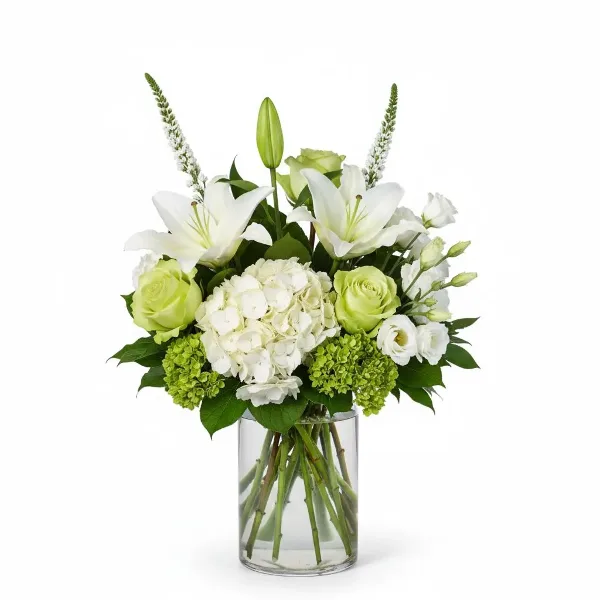 A floral arrangement with white lilies, green roses, and white hydrangeas in a clear glass vase.