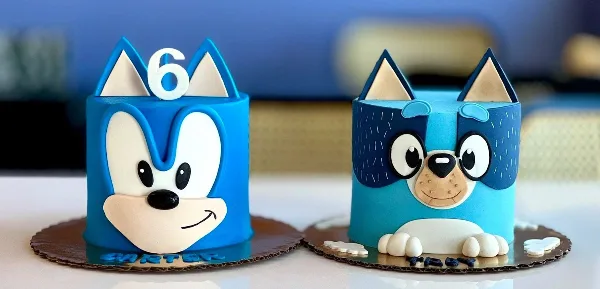 A custom blue cake decorated with a cartoon character face and the number 6.