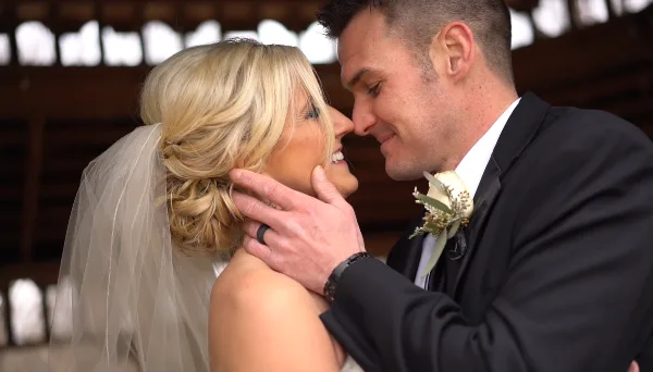 A bride and groom sharing an intimate moment, with the groom gently touching the bride's face.