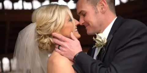 A bride and groom sharing an intimate moment, with the groom gently touching the bride's face.