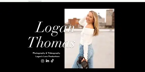 A smiling woman holding a professional camera, standing outdoors with a city background.