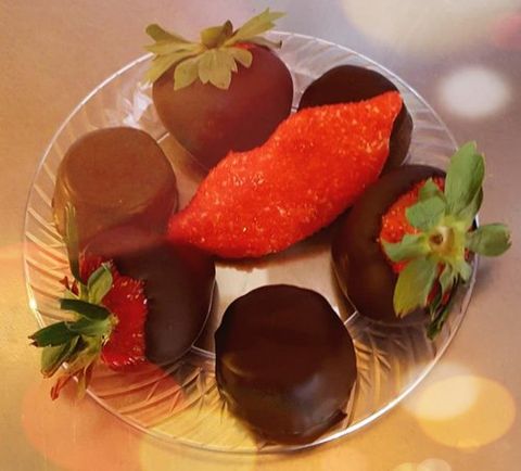 A plate of chocolate-dipped strawberries and chocolate truffles