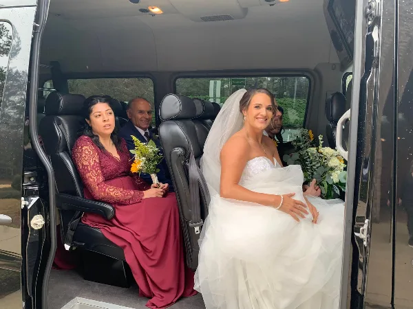 Bride leaving church in a limousine, wedding shuttle by Bolt Transportation