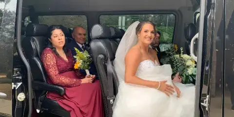 Bride leaving church in a limousine, wedding shuttle by Bolt Transportation