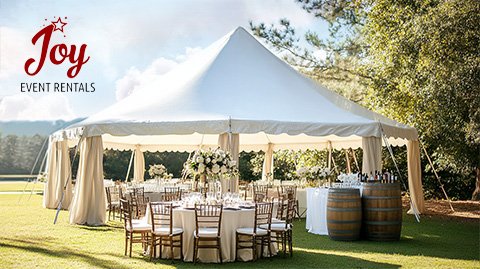 A white event tent set up on a lawn with tables, chairs, and floral centerpieces.