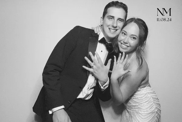 A black and white photo of a couple posing together with a custom monogram and date in the corner.
