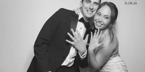A black and white photo of a couple posing together with a custom monogram and date in the corner.