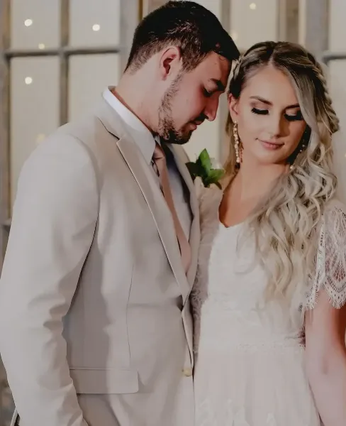 A bride and groom standing together in a wedding setting.