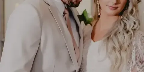 A bride and groom standing together in a wedding setting.
