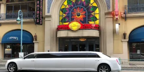 A white stretch limousine parked on a street in front of a building with a stained-glass window.