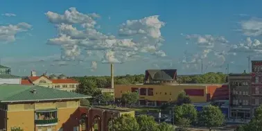 Exterior view of the Macon-Bibb County government complex and courthouse buildings under a blue sky.