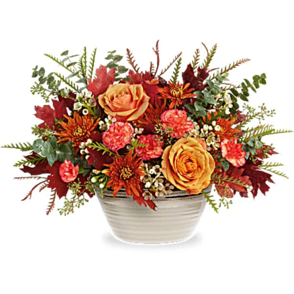 Autumn floral arrangement in a white ceramic bowl with orange and pink blooms
