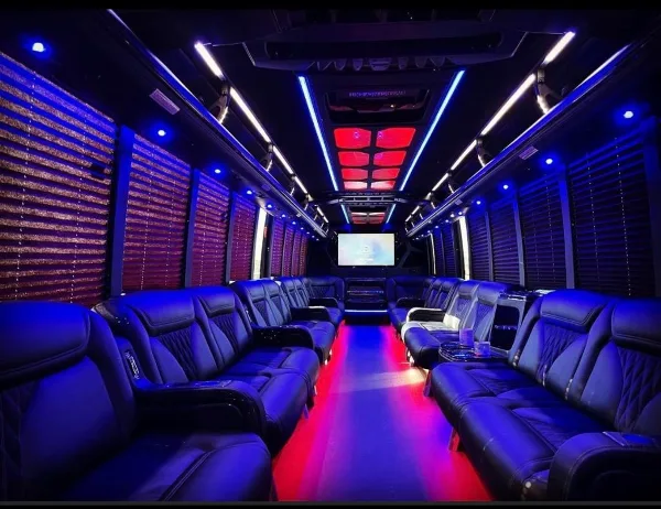 Interior of a luxury limousine with black leather seats and blue and red LED lighting.