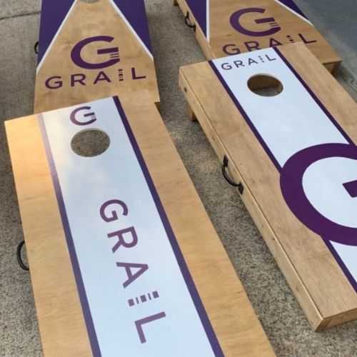 Custom wooden cornhole boards with purple and white branding
