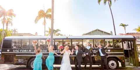 A wedding party posing with a black school bus