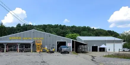 Exterior view of the States Rental Service building with various construction and landscaping equipment parked in the lot.