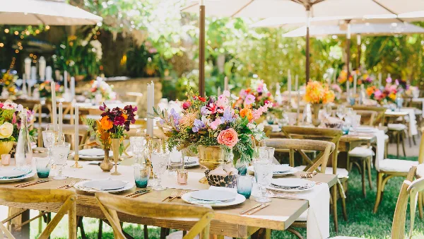 Outdoor event table setting with floral centerpieces and glassware