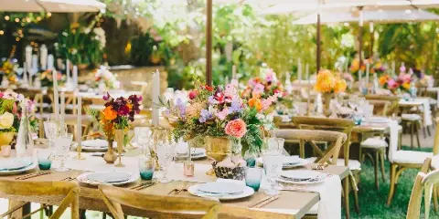 Outdoor event table setting with floral centerpieces and glassware