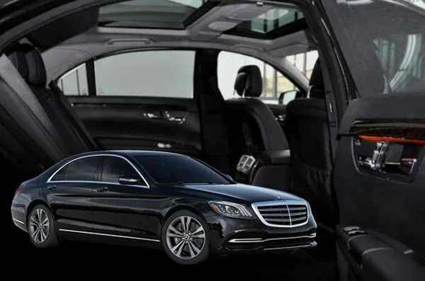 Black luxury sedan with open doors showing leather interior and sunroof
