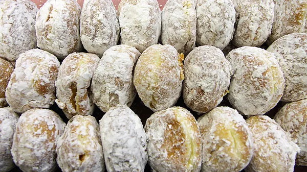 A tray of powdered-sugar coated paczki pastries