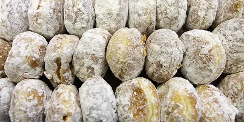 A tray of powdered-sugar coated paczki pastries