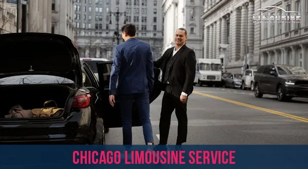 A professional chauffeur in a suit opens the door of a black sedan for a passenger on a city street.