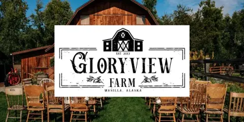 Exterior view of the Gloryview Farm rustic barn wedding venue with outdoor seating and signage.