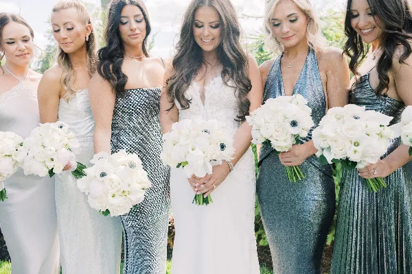 A bride and bridesmaids holding white floral bouquets