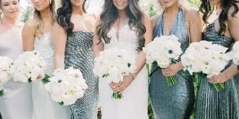 A bride and bridesmaids holding white floral bouquets