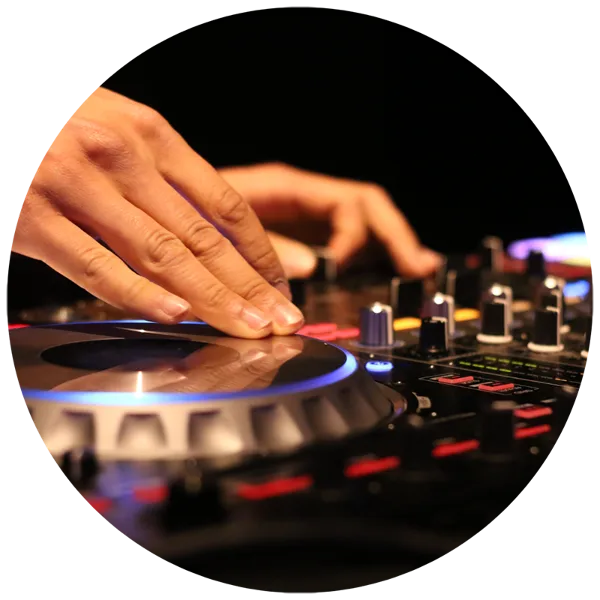 Close-up of a DJ's hands adjusting controls on a professional turntable and mixer with illuminated buttons.