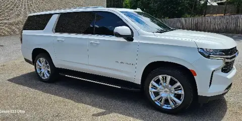A white Chevrolet Suburban SUV parked on a paved surface.