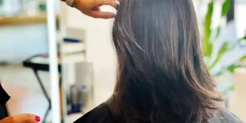 A stylist styling a client's hair in a salon.