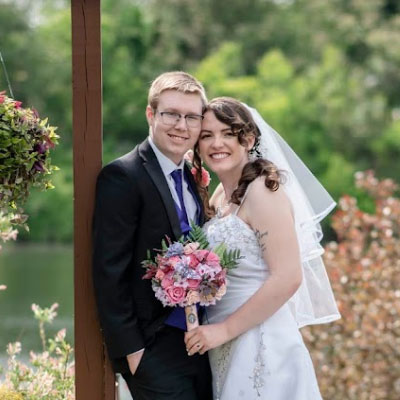 A bride and groom posing together outdoors with a bouquet, representing a wedding at the venue.