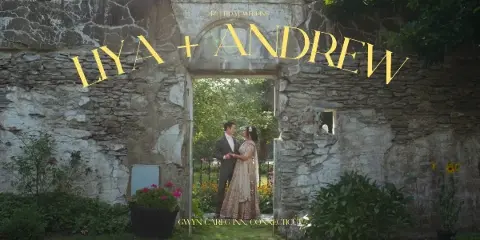 Cinematic wedding film title card showing a couple standing in a stone archway with the text 'LIYA + ANDREW'.