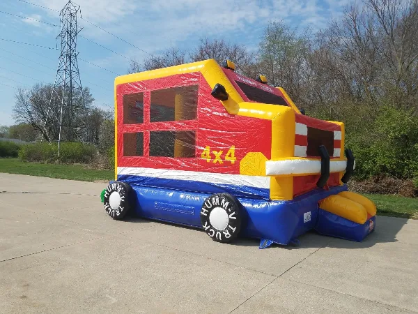 A colorful inflatable bouncer shaped like a truck, set up outdoors on a concrete surface.