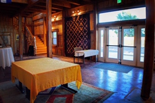 Interior view of a rustic wooden barn event venue with a staircase and tables set up for an event.