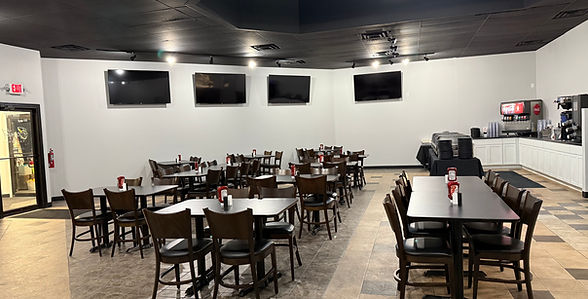 Interior view of a catering business dining area with tables, chairs, and a beverage station.