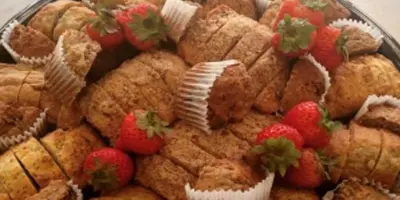 A large platter of baked pastries garnished with fresh strawberries.