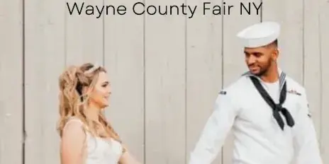 A bride and groom holding hands in front of a rustic wooden wall.