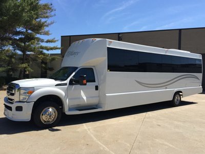 A white party bus parked in a lot.
