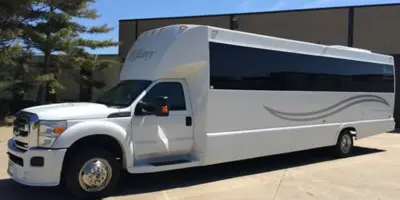 A white party bus parked in a lot.